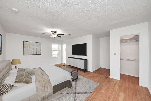 5103 Diamond Springs Dr, Missouri City, TX 77459 - bedroom with light wood-style flooring, a ceiling fan, baseboards, a textured ceiling, and a closet