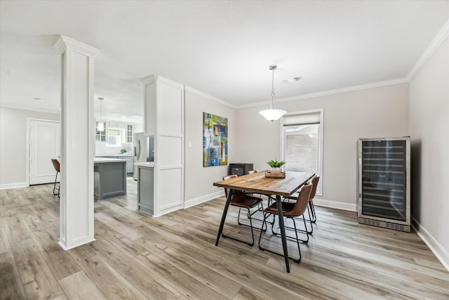 2514 Briarbrook Dr, Houston, TX 77042 - dining space featuring beverage cooler, light wood-type flooring, healthy amount of natural light, baseboards, and ornamental molding
