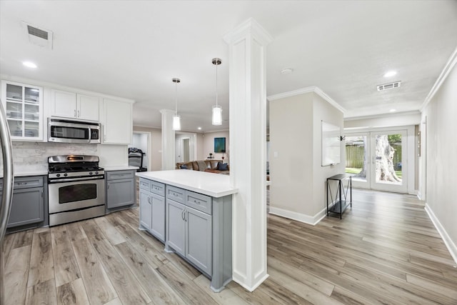 2514 Briarbrook Dr, Houston, TX 77042 - kitchen with appliances with stainless steel finishes, gray cabinetry, crown molding, light countertops, and light wood-style flooring