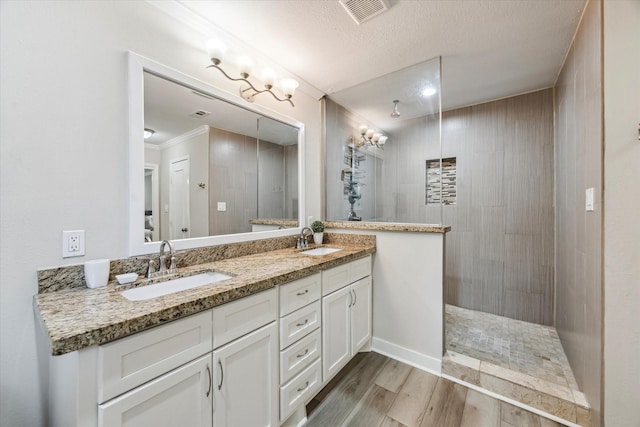 2514 Briarbrook Dr, Houston, TX 77042 - bathroom featuring wood finished floors, double vanity, walk in shower, and a textured ceiling