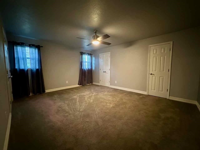 207 Lucky Dr, Silsbee, TX 77656 - unfurnished bedroom featuring baseboards, dark colored carpet, and ceiling fan