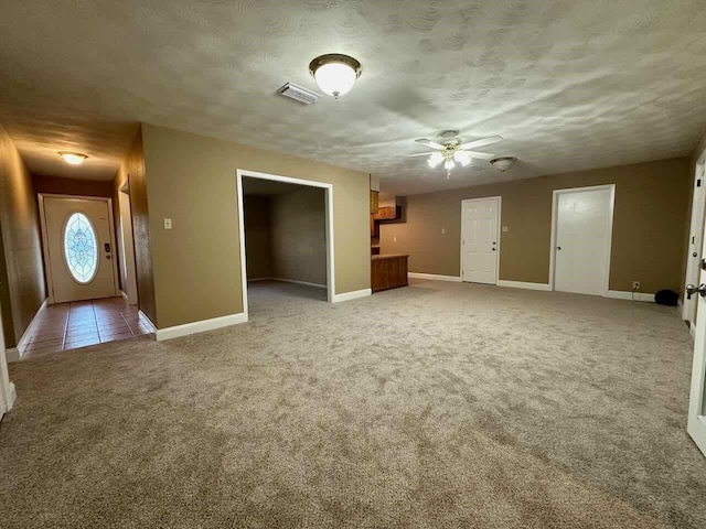 207 Lucky Dr, Silsbee, TX 77656 - unfurnished living room with carpet floors, baseboards, ceiling fan, and a textured ceiling