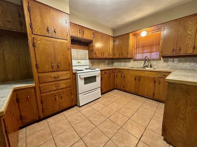 207 Lucky Dr, Silsbee, TX 77656 - kitchen featuring white electric stove, a sink, decorative backsplash, brown cabinets, and light countertops