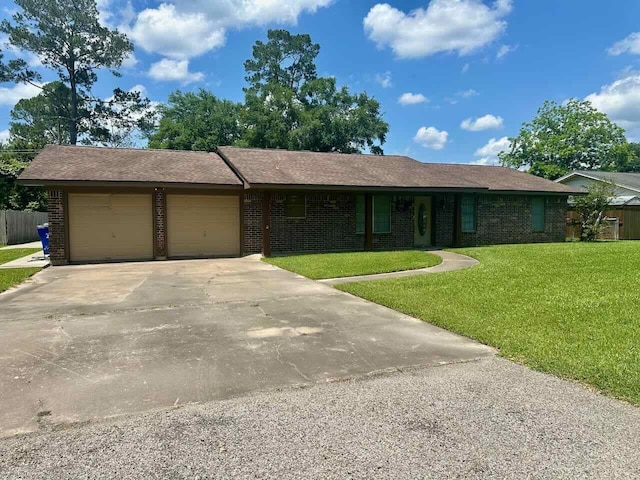 207 Lucky Dr, Silsbee, TX 77656 - ranch-style home with a garage, a front lawn, concrete driveway, and brick siding
