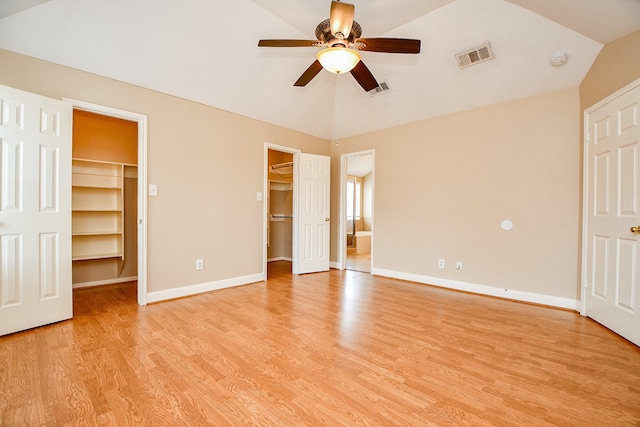 11707 Turtle Lake Dr, Houston, TX 77064 - unfurnished bedroom featuring a walk in closet, vaulted ceiling, light wood-style flooring, baseboards, and a ceiling fan