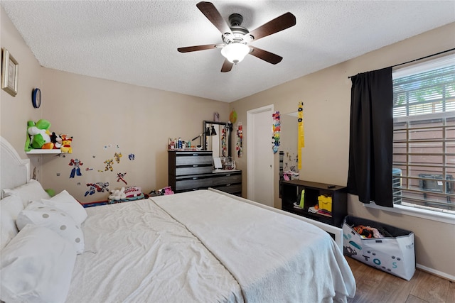 12574 Newbrook Dr, Houston, TX 77072 - bedroom featuring wood finished floors, a textured ceiling, and ceiling fan