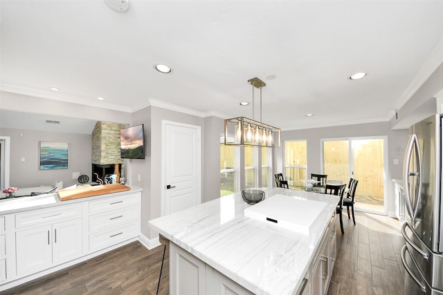 525 Rancho Bauer Dr, Houston, TX 77079 - kitchen with freestanding refrigerator, dark wood-style flooring, ornamental molding, white cabinetry, and a center island