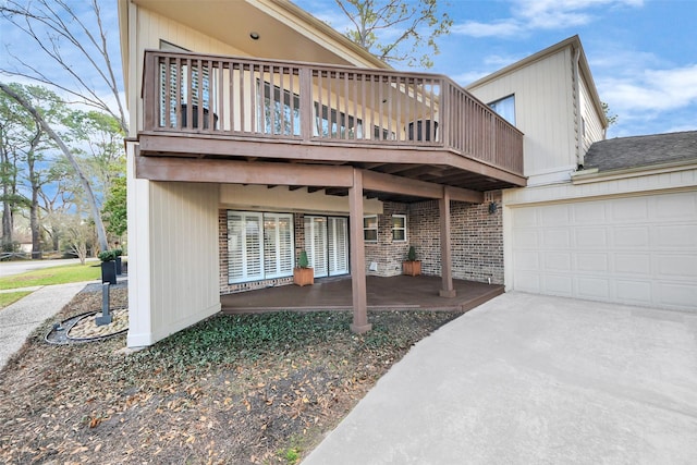 525 Rancho Bauer Dr, Houston, TX 77079 - view of front facade with brick siding, concrete driveway, an attached garage, and a wooden deck
