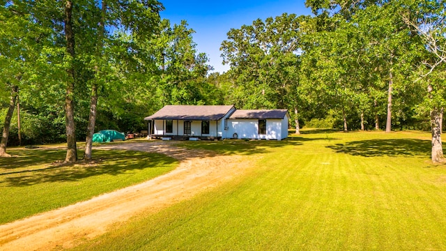 60 W Sierra Rd, Coldspring, TX 77331 - view of front facade featuring dirt driveway, covered porch, and a front yard