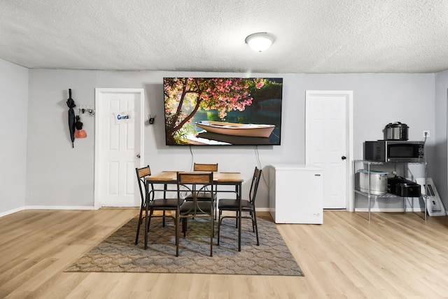 60 W Sierra Rd, Coldspring, TX 77331 - dining room with wood finished floors, a textured ceiling, and baseboards
