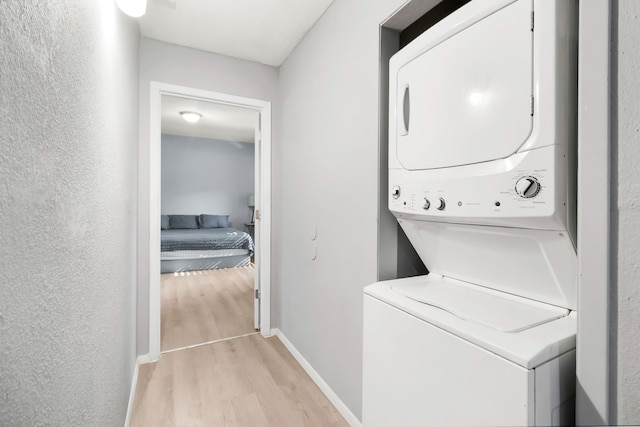 60 W Sierra Rd, Coldspring, TX 77331 - laundry room with stacked washer / drying machine, light wood-style flooring, and baseboards