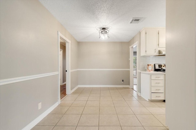 2003 Sieber Dr, Houston, TX 77017 - unfurnished dining area with a textured ceiling, light tile patterned floors, and baseboards