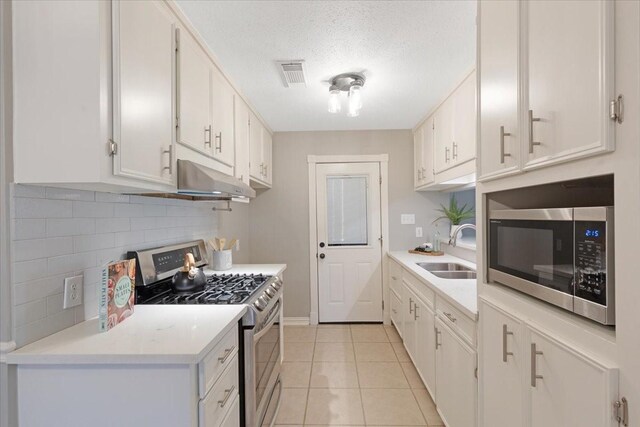 2003 Sieber Dr, Houston, TX 77017 - kitchen with appliances with stainless steel finishes, a sink, under cabinet range hood, tasteful backsplash, and light countertops