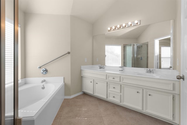 16503 Brightling Ln, Houston, TX 77090 - bathroom featuring healthy amount of natural light, vaulted ceiling, tile patterned floors, a stall shower, and double vanity