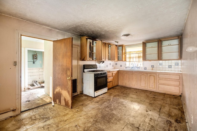 1306 Laurel St, La Marque, TX 77568 - kitchen featuring gas stove, glass insert cabinets, open shelves, a textured ceiling, and a sink