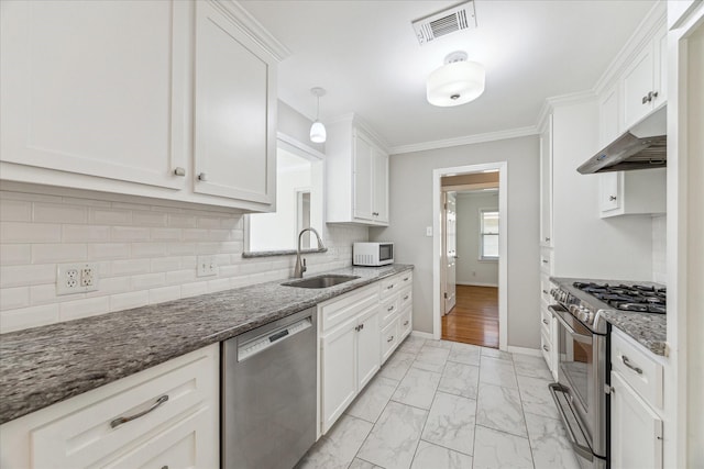 2322 Lamonte Ln, Houston, TX 77018 - kitchen with appliances with stainless steel finishes, a sink, under cabinet range hood, white cabinets, and ornamental molding