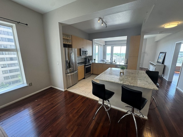 3505 Sage Rd Unit 602, Houston, TX 77056 - kitchen with stainless steel appliances, a sink, light wood-type flooring, and baseboards
