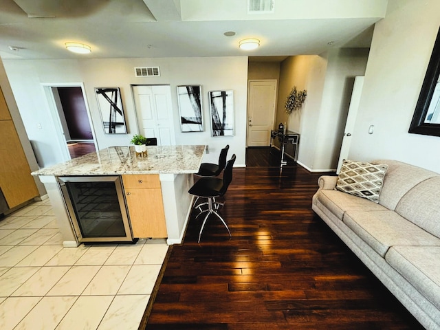 3505 Sage Rd Unit 602, Houston, TX 77056 - kitchen with beverage cooler, open floor plan, light stone countertops, baseboards, and light wood-type flooring