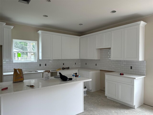6322 Sayers St, Houston, TX 77026 - kitchen featuring backsplash, white cabinetry, and a sink