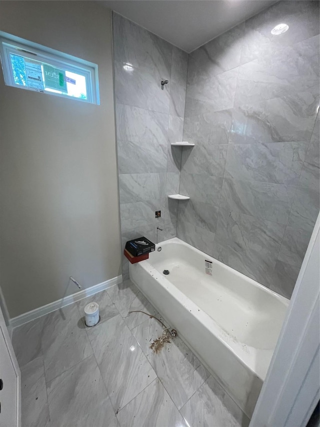 6322 Sayers St, Houston, TX 77026 - full bathroom with marble look tiles, shower / bathtub combination, and baseboards