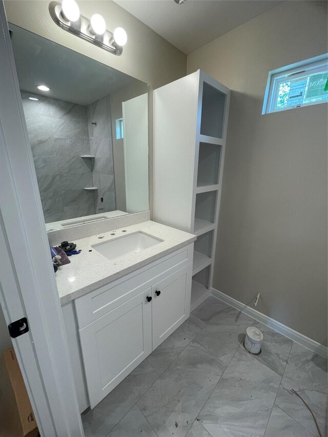 6322 Sayers St, Houston, TX 77026 - bathroom featuring marble finish floors, vanity, a shower, and baseboards