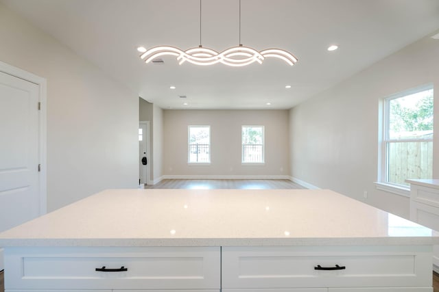 6322 Sayers St, Houston, TX 77026 - kitchen with white cabinets, a center island, light stone countertops, open floor plan, and recessed lighting
