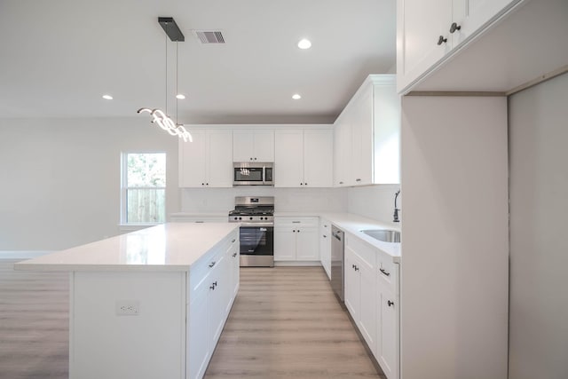 6322 Sayers St, Houston, TX 77026 - kitchen with appliances with stainless steel finishes, a center island, light wood finished floors, light countertops, and recessed lighting
