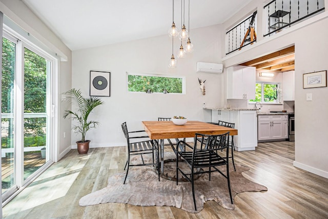 817 Bryan Ave, Seabrook, TX 77586 - dining space with a wall mounted AC, light wood-style floors, vaulted ceiling, and baseboards
