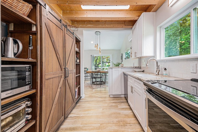 817 Bryan Ave, Seabrook, TX 77586 - kitchen featuring stainless steel appliances, a sink, wooden ceiling, white cabinets, and light wood-style flooring