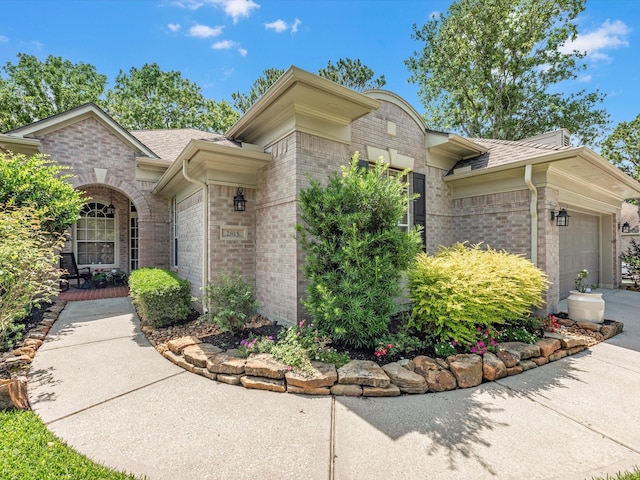 2815 Halton Ct, Kingwood, TX 77345 - view of property exterior with an attached garage, brick siding, and a shingled roof