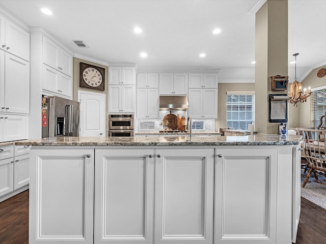 2815 Halton Ct, Kingwood, TX 77345 - kitchen featuring stainless steel appliances, under cabinet range hood, crown molding, white cabinetry, and recessed lighting
