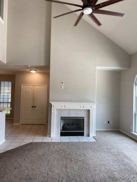 17523 Ginger Fields Ln, Tomball, TX 77377 - unfurnished living room with high vaulted ceiling, ceiling fan, carpet floors, a fireplace, and tile patterned floors