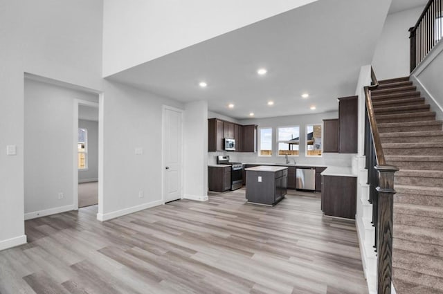 8802 Cecil Garden Ln, Cypress, TX 77433 - kitchen with appliances with stainless steel finishes, a sink, a kitchen island, dark brown cabinets, and light countertops