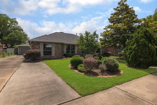 3314 Park Meadows Ave, Deer Park, TX 77536 - view of front facade featuring a front lawn, a garage, stone siding, and driveway