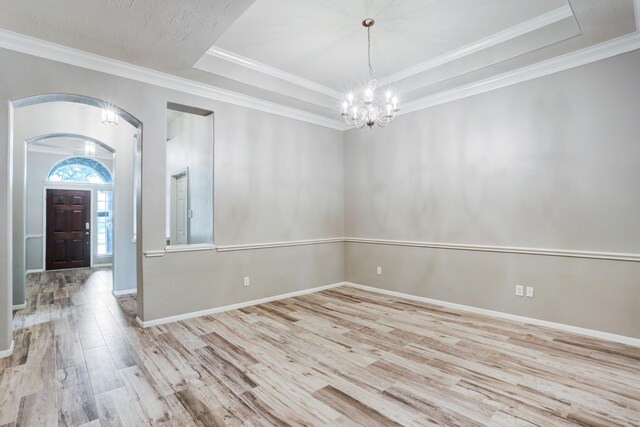 431 Cardinal Oaks, League City, TX 77565 - spare room featuring a chandelier, wood finished floors, a tray ceiling, arched walkways, and baseboards