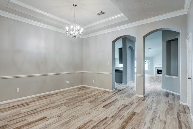 431 Cardinal Oaks, League City, TX 77565 - unfurnished room featuring light wood finished floors, a chandelier, a tray ceiling, a fireplace, and baseboards