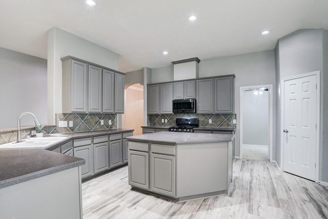 431 Cardinal Oaks, League City, TX 77565 - kitchen with stainless steel microwave, range, gray cabinets, a sink, and arched walkways