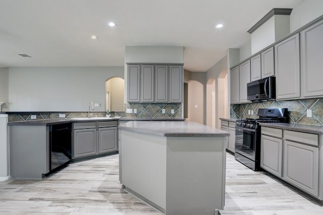 431 Cardinal Oaks, League City, TX 77565 - kitchen with stainless steel gas range oven, gray cabinets, arched walkways, a sink, and recessed lighting