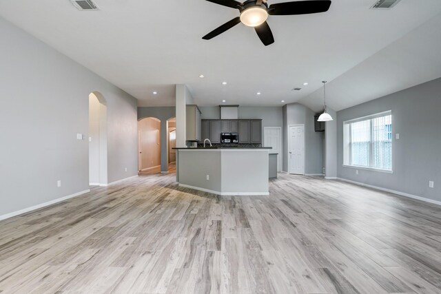 431 Cardinal Oaks, League City, TX 77565 - unfurnished living room featuring arched walkways, a ceiling fan, baseboards, light wood-style flooring, and vaulted ceiling
