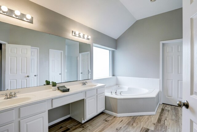431 Cardinal Oaks, League City, TX 77565 - bathroom featuring vaulted ceiling, wood finished floors, double vanity, and a bath