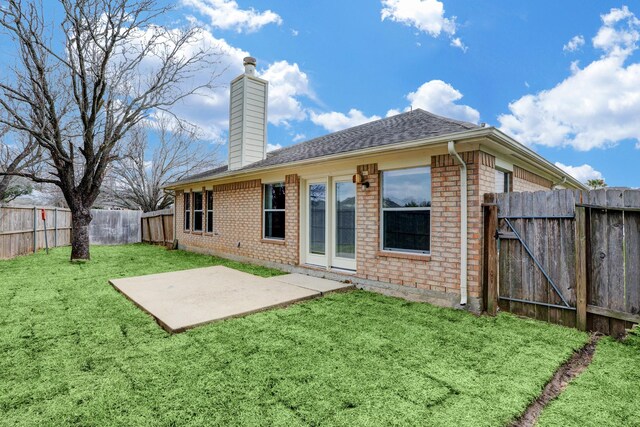 431 Cardinal Oaks, League City, TX 77565 - back of property with a chimney, brick siding, a patio, a shingled roof, and a gate