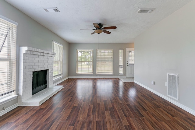 7402 Grackle Dr, Cypress, TX 77433 - unfurnished living room featuring ceiling fan, baseboards, a fireplace, wood finished floors, and a textured ceiling