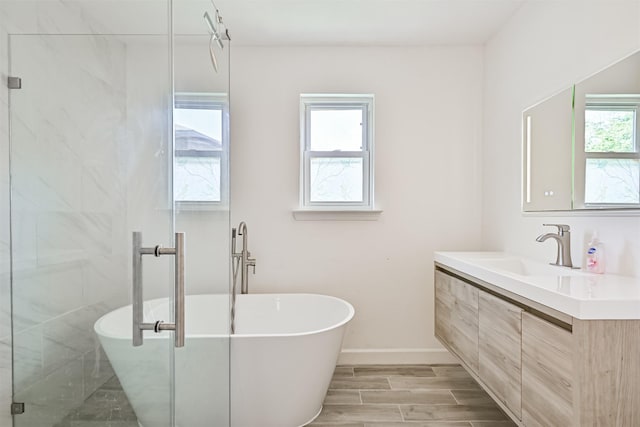 16358 Havenpark Dr, Houston, TX 77059 - bathroom with vanity, a freestanding tub, a stall shower, wood finished floors, and baseboards