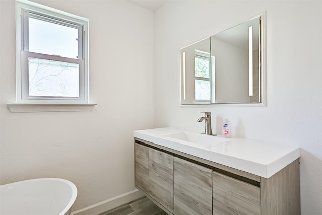 16358 Havenpark Dr, Houston, TX 77059 - full bath featuring vanity, a soaking tub, wood finished floors, and baseboards