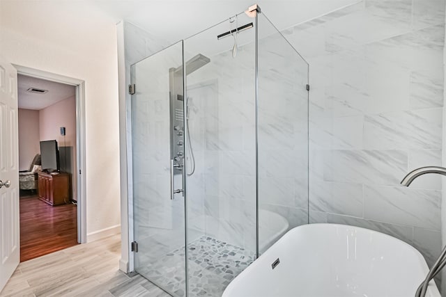16358 Havenpark Dr, Houston, TX 77059 - full bath featuring a freestanding tub, a shower stall, and wood finished floors