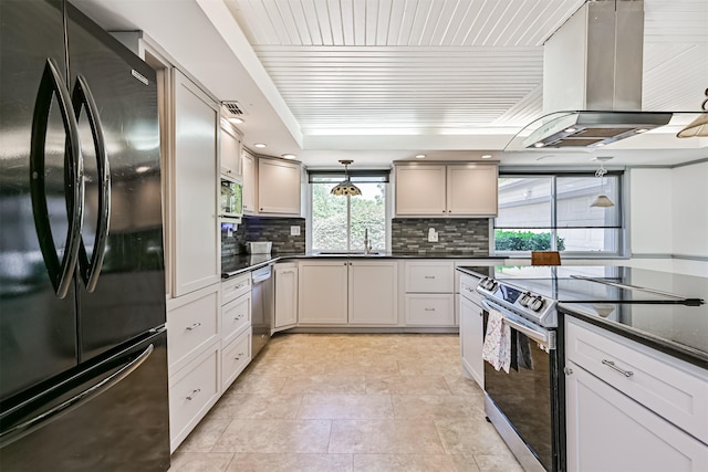 16358 Havenpark Dr, Houston, TX 77059 - kitchen with appliances with stainless steel finishes, island exhaust hood, dark countertops, tasteful backsplash, and decorative light fixtures