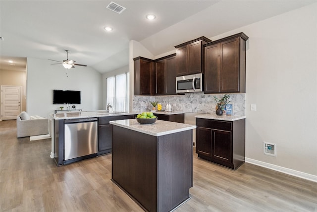 18414 Christine Elizabeth Ln, New Caney, TX 77357 - kitchen with stainless steel appliances, open floor plan, a sink, dark brown cabinetry, and a ceiling fan