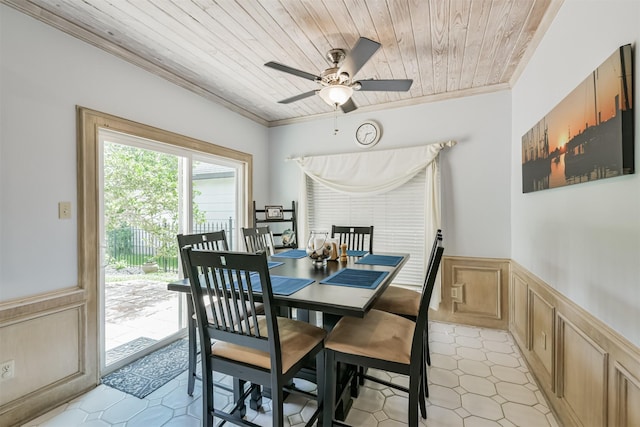8410 Atascocita Lake Way, Humble, TX 77346 - dining room with crown molding, wainscoting, wood ceiling, a ceiling fan, and a decorative wall