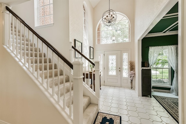 8410 Atascocita Lake Way, Humble, TX 77346 - foyer entrance featuring stairs, a high ceiling, a chandelier, and tile patterned floors