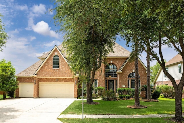 10707 Mandavilla Dr, Houston, TX 77095 - traditional home with brick siding, a front lawn, concrete driveway, roof with shingles, and a garage